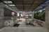 Elevated deck with two built-in grilling stations against a stone wall with a TV next to two round 4-person dining tables