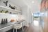 apartment entryway with built-in desk featuring open shelves and black granite counter tops, adjacent to kitchen with floor-to-ceiling windows