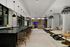 club room area with catering kitchen and counter seating and 3 lounge seating arrangements, partially separated by curtains
