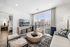 apartment living room with couch, chairs, and TV, and 3 large sliding glass doors