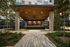outdoor arbor with wood paneled ceiling, 3 tvs, and counter-height bar with 9 stools around it