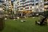 greenspace in apartment courtyard with lawn games, adirondack chairs, and string lighting
