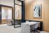 coworking area with two waterfall stone 2-seater workstations separated by glass partition