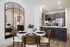 apartment dining area with 4-person table next to kitchen with counter-height seating, white stone counters and brown wood cabinets
