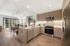 Kitchen with a refrigerator, oven, microwave and dishwasher leading towards the dining and living room area