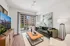 Living room with a TV, sofa sitting and a standing balcony