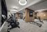 fitness center with row of carddio machines and weight machines beyond