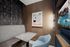 private meeting room with small work table with bench seating facing a TV on the wall