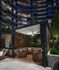 outdoor lounge area with wicker furniture and ambient lighting, surrounded by lush greenery.