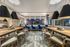 Elegant communal lounge with modern pendant lighting, plush blue chairs, and large windows offering a scenic view, ideal for social gatherings and meetings.