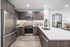 Modern kitchen with sleek stainless steel appliances, dark wood cabinetry, and a spacious white island counter.