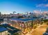 Captivating cityscape view of a modern apartment complex against a vibrant evening skyline, offering urban living at its finest.