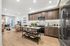 Modern open-concept kitchen and living area featuring sleek wood cabinets, elegant marble backsplash, and a stylish island with ample storage.