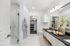 Luxurious modern bathroom with elegant marble flooring, spacious glass shower, and contemporary double vanity accented with decorative plants.