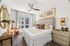 Bright and elegant bedroom with chic decor, featuring a cozy bed, modern ceiling fan, large window, and stylish accents.
