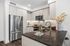 Modern kitchen with sleek stainless steel appliances, elegant marble backsplash, and stylish dark countertops.