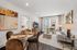 Elegant open-concept living room with cozy seating, chic dining area, and stunning natural light from large windows.