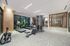 Luxurious fitness center featuring state-of-the-art cardio machines, strength training equipment, and expansive windows with garden views.