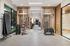 Contemporary gym space with sleek wooden accents featuring a variety of modern exercise equipment and a serene view through large windows.