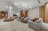 Luxurious modern living room with elegant chandeliers, plush seating, marble accents, and wooden paneling.