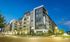 Modern apartment building with sleek architectural design and vibrant evening lighting, inviting ambiance in an urban setting.