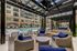 Luxurious outdoor pool area with plush wicker seating and modern pergolas, perfect for relaxation and entertainment.