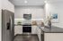 Modern kitchen with sleek stainless steel appliances, elegant cabinetry, and a stylish marble backsplash.