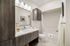 Elegant bathroom featuring modern fixtures, sleek wooden cabinetry, and a stylish shower-tub combo, exuding a spa-like ambiance.