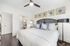 Elegant bedroom with sleek modern design, featuring a stylish bed with plush pillows, contemporary ceiling fan, and chic wall art, offering ultimate comfort and sophistication.