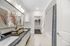 Luxurious bathroom showcasing elegant décor, dual sinks, stylish vanity, and spacious walk-in closet in modern apartment.
