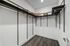 Spacious walk-in closet with sleek dark shelving, modern clothing hangers, and stylish storage baskets.