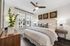 Chic bedroom with modern decor, featuring a cozy bed, stylish artwork, and elegant lighting, creating a serene atmosphere.