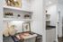 Chic home office nook with elegant decor, featuring modern shelving, lush greenery, and sophisticated artwork.
