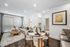 Modern open-concept living and dining area with cozy seating, elegant decor, and natural light streaming through large windows.