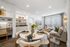 Contemporary living room with plush sofa, chic dining setup, and sleek shelving, accentuated by natural light from large windows.