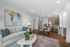 Inviting open-plan living area with a modern kitchen, elegant dining set, and chic lounge featuring contemporary artwork and stylish decor.