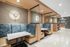 Elegant and modern lobby featuring stylish booth seating with plush blue and tan upholstery, marble-topped tables, and sophisticated wall lighting.