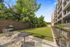 Charming outdoor area with modern patio seating, manicured lawn, and lush greenery, ideal for relaxation and social gatherings.