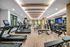 Modern fitness center with state-of-the-art treadmills, sleek wooden floors, and ample natural lighting.