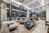 Luxurious modern lounge with a spacious open layout, featuring stylish seating, large windows, and elegant lighting fixtures that create a warm and inviting atmosphere.