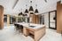 Luxurious modern kitchen with sleek lighting, spacious island, and elegant seating, perfect for entertaining.
