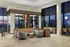 Luxurious open-concept living space with modern furnishings, large windows, and stunning city views.