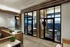 Elegant modern apartment interior featuring stylish seating area, floor-to-ceiling windows with panoramic city views, and chic pendant lighting.