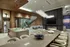 Luxurious open-plan living space with sleek modern kitchen, elegant dining area, and cozy fireplace under stunning chandelier lighting.