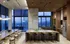 Luxurious high-rise kitchen with sleek modern design, featuring floor-to-ceiling windows, elegant pendant lights, and a spacious island, offering stunning city views.