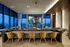 Luxurious high-rise living room with panoramic city view, featuring stylish seating, a large screen for entertainment, and modern decor.