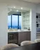 Luxurious wet bar area with sleek cabinetry, modern glass shelving, and panoramic city views for the ultimate entertaining space.