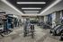 Modern fitness center equipped with state-of-the-art exercise machines, free weights, and a punching bag, offering a sleek and spacious workout environment.