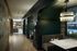 Sophisticated interior corridor with elegant lighting, modern booth seating, and a view of a luxurious outdoor pool.