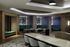 Elegant lounge area with modern decor, featuring plush turquoise seating, geometric wall designs, and a sleek marble countertop.